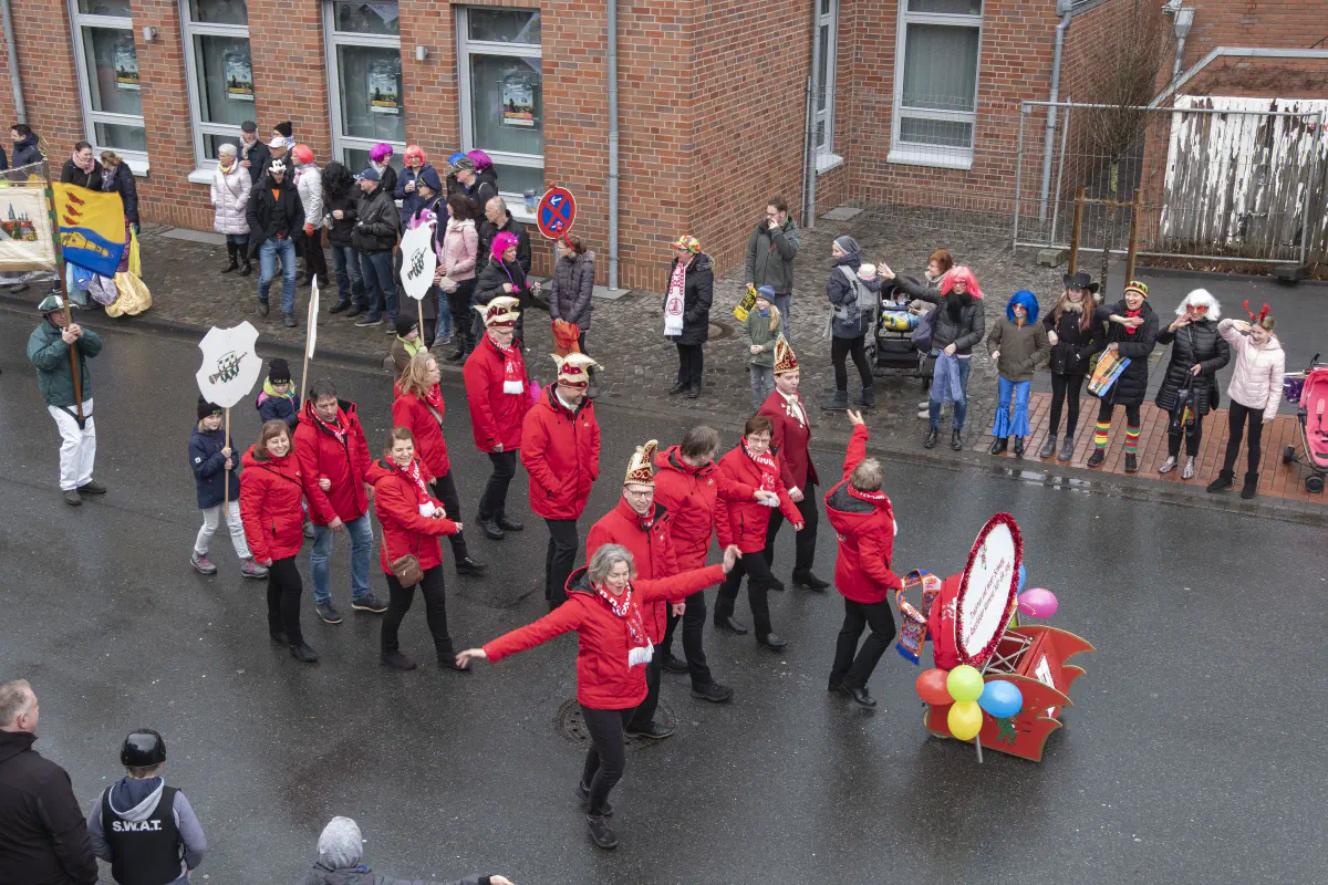 Fußgruppe des RRZ in roten Jacken und Narrenkappen beim Rosenmontagszug